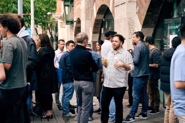 verschiedene Menschen vor einer Bar in einer Unterhaltung.